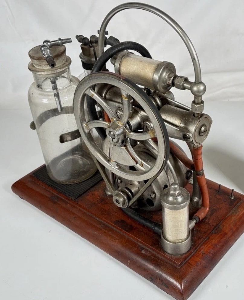 Figure 3 — The drive side, which is where completeness shows. Belt, flywheel, motor and pump are all present and correctly related here; a machine photographed from this angle with a missing belt or a substit…