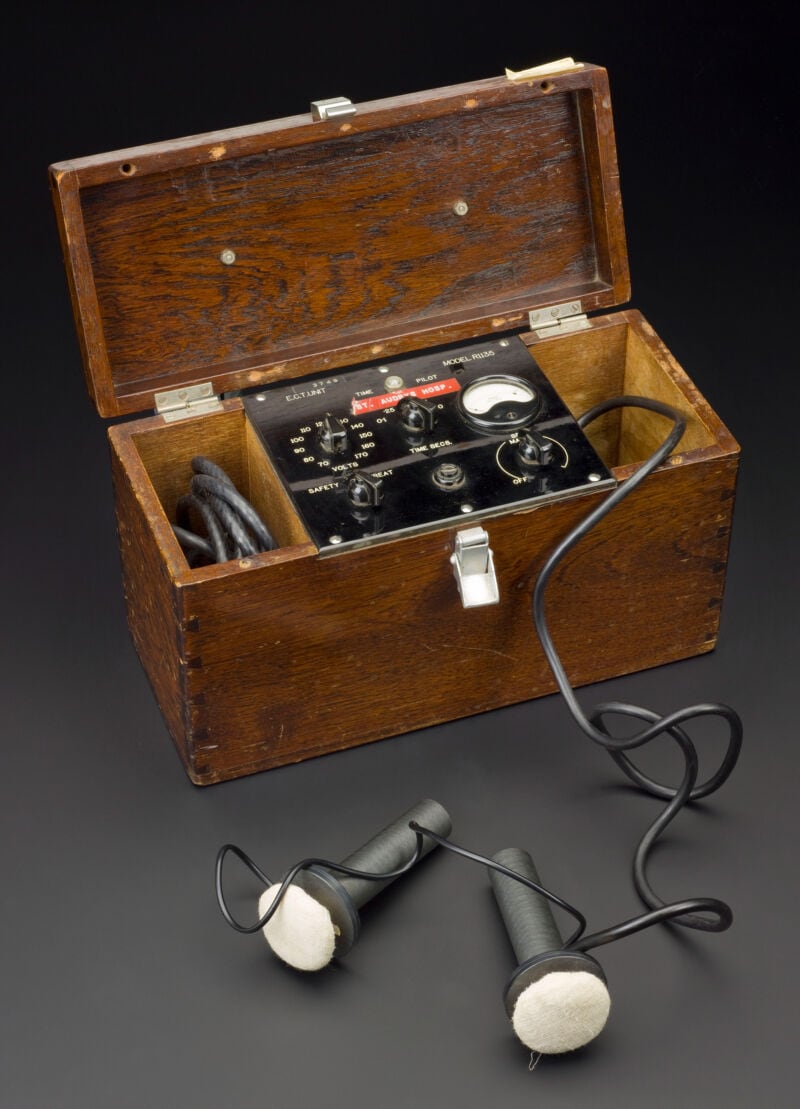 Figure 2 — A cased electroconvulsive apparatus from the mid-twentieth century held in a medical collection, representative of the "modified" era in which anaesthesia and muscle relaxants had become standard; …
