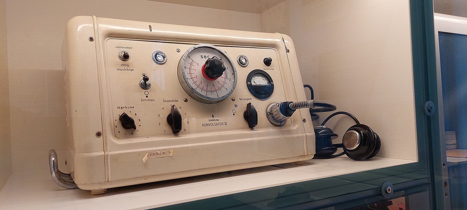 Figure 4 — An electroshock apparatus of 1946 — dialled panel, meter, and its electrode leads coiled beside it. For a collector this is the identification problem in miniature: read the panel legends and the m…