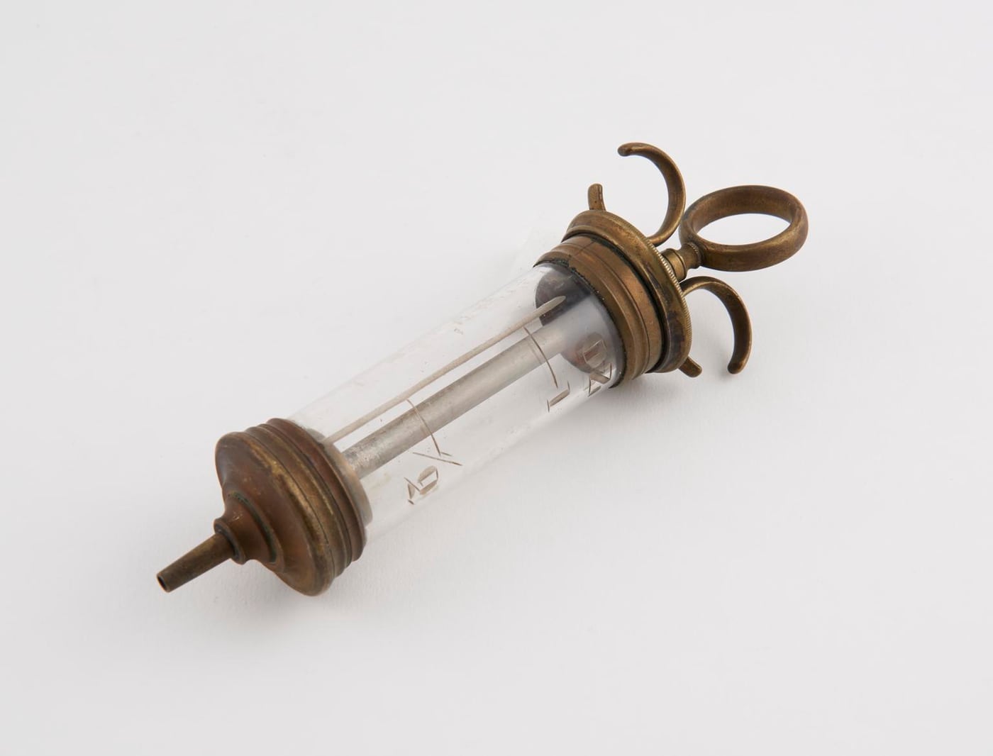Figure 2 — A nickel-plated brass hand-pump body with the plating worn through to yellow brass at the wear points — the construction (brass core, nickel skin) and the pattern of wear both help place an outfit …