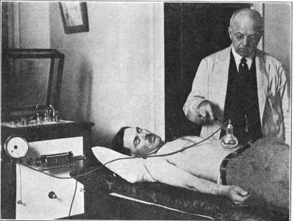 Figure 4 — A partially evacuated glass vacuum electrode of the kind Frederick Finch Strong introduced in the 1890s, glowing where the high-frequency field ionizes the residual gas inside — the object that wou…