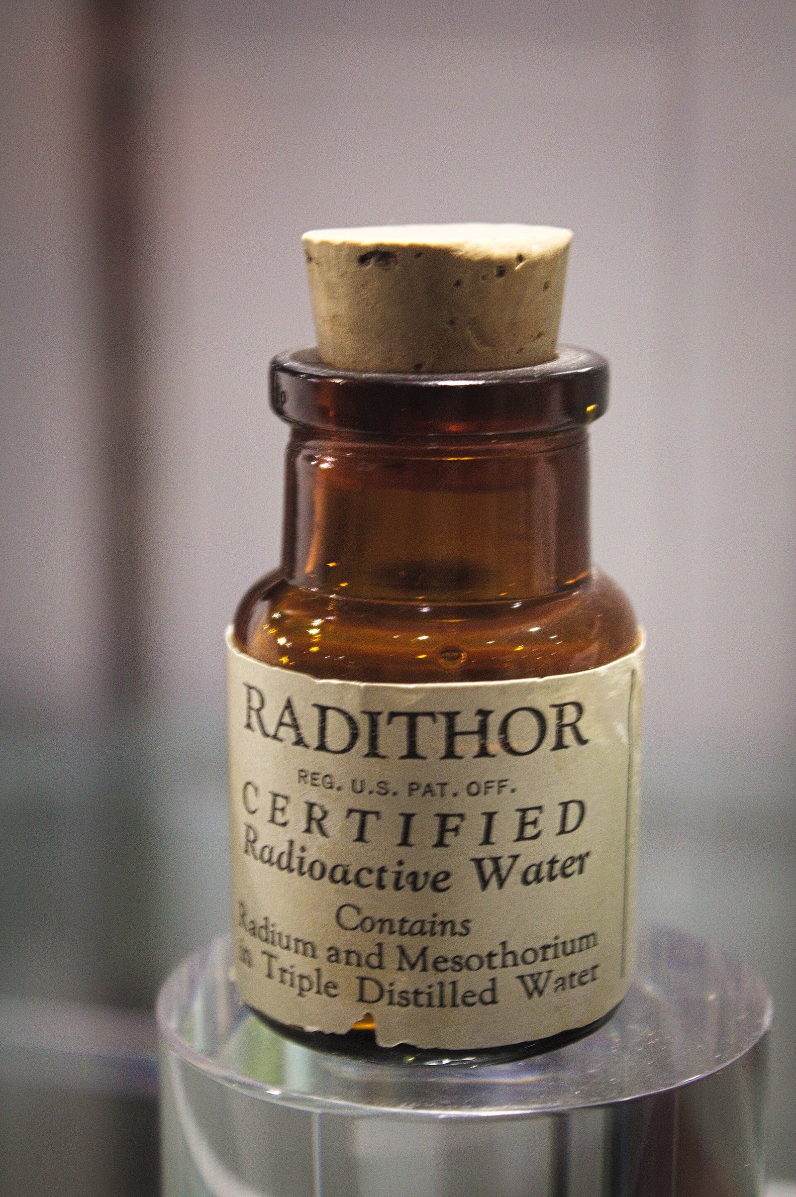 Figure 6 — A Radithor bottle — "Certified Radioactive Water… Contains Radium and Mesothorium in Triple Distilled Water." The label is not a euphemism or a hedge. Bailey sold precisely what it says, by the cas…