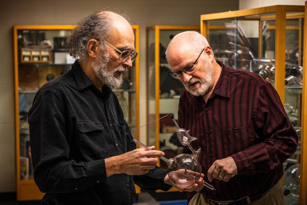 Figure 3 — A health physicist surveying a radium quack-cure object with a Geiger-Müller pancake probe — the documented practice of characterising a piece before it is catalogued, handled, or displayed.