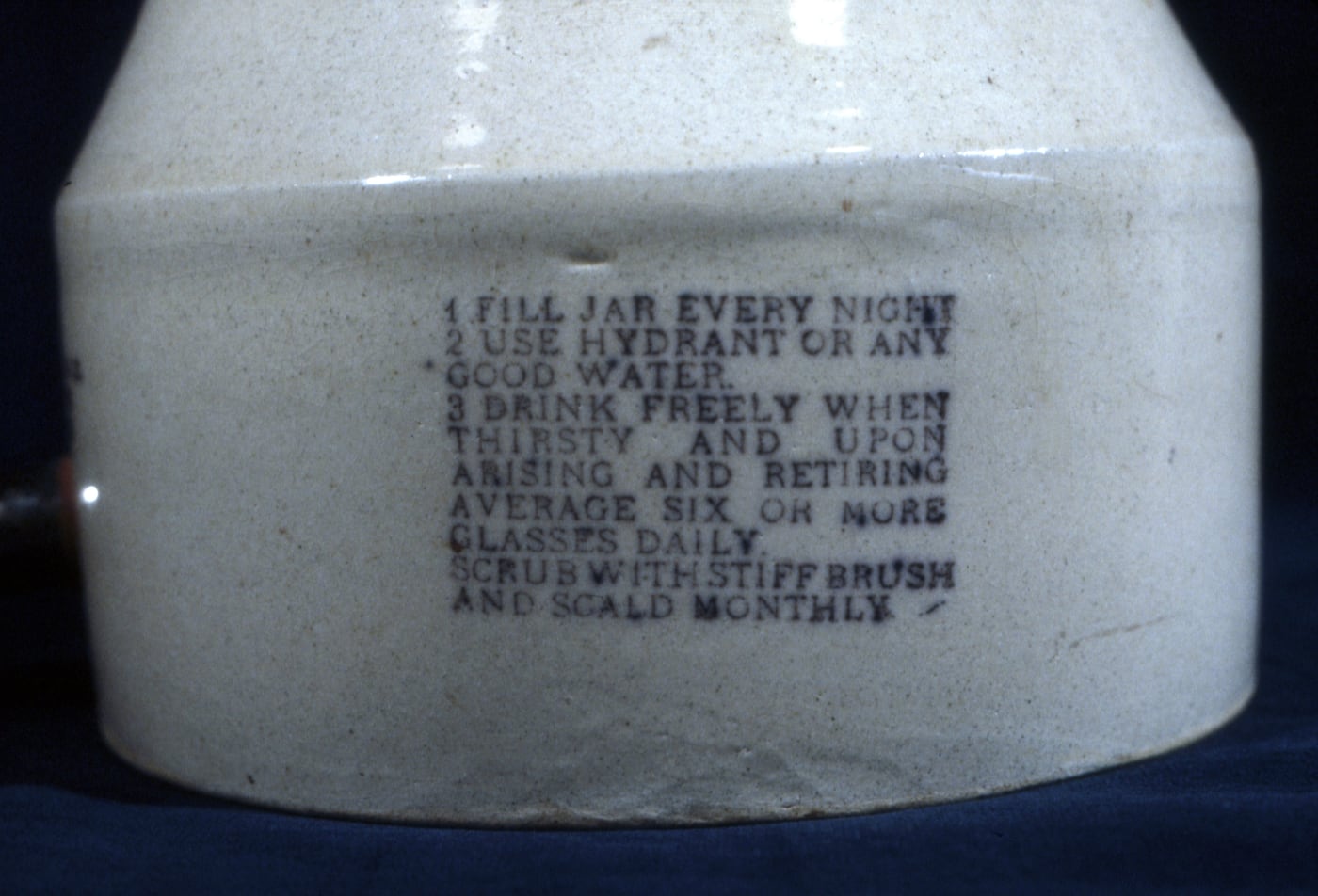 Figure 3 — A Radium Ore Revigator crock with its spigot and printed instructions to "fill every night" and drink six or more glasses daily. The porous inner wall was lined with carnotite ore, so that overnigh…