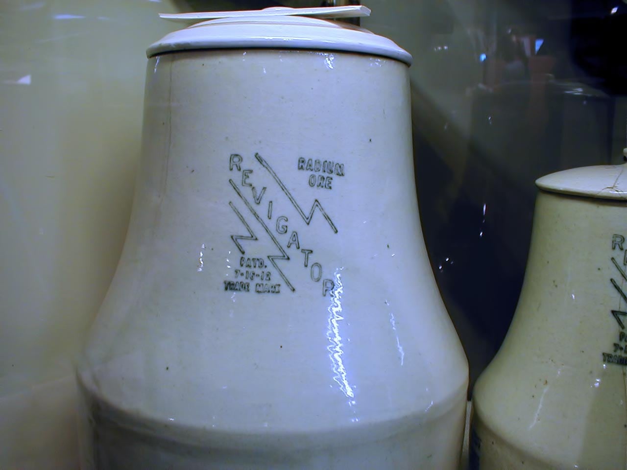 Figure 2 — A "Radium Ore Revigator" water crock: glazed stoneware with a radioactive uranium-ore lining and a spigot, sold by the Radium Ore Revigator Company of San Francisco. Buyers were told to fill it nig…