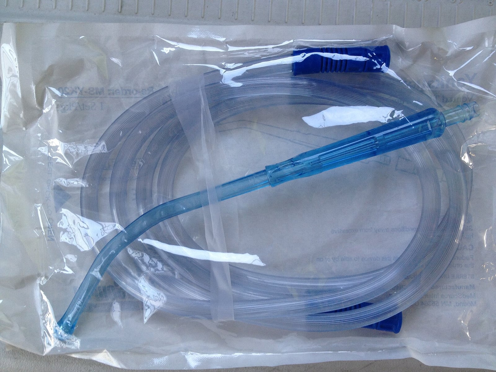Figure 4 — A Yankauer suction tip as it is issued today — sterile, disposable, plastic, and carried on every ambulance. The material changed; the geometry did not. This is Yankauer's 1907 shape, still in dail…