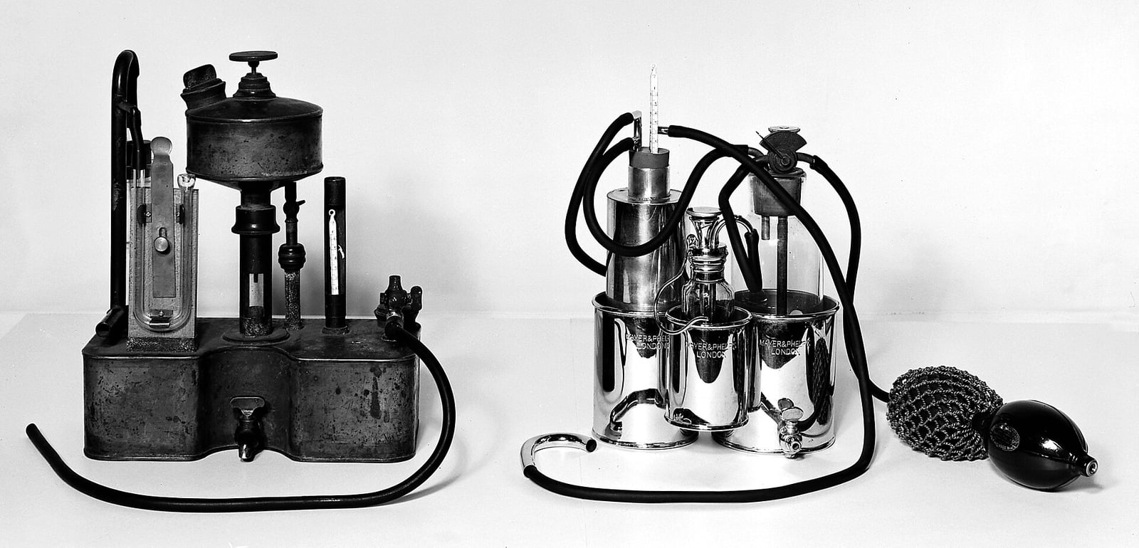Figure 1 — Anesthesia apparatus laid out for a 1946 exhibition — inhalers, vaporizing bottles, tubing and a facepiece, each object given room to be read as an object. It is the register this wing aims for: hi…